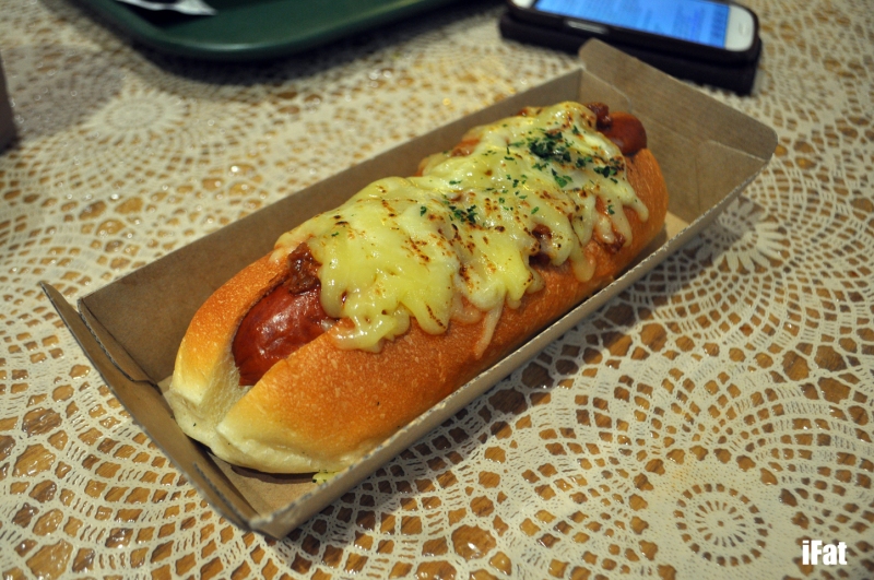 Cheese hot dog featuring a kransky sausage, curry flavoured cabbage, vegetable salsa and melted cheese