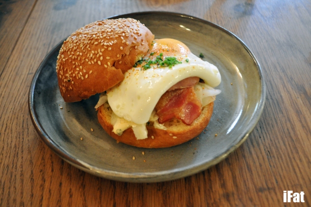 The Merchant with crispy bacon, egg, pickled slaw, and ranch dressing on a warm brioche bun